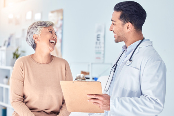 A doctor with a stethoscope around his neck discussing with a patient