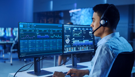 A man working on an analytics using two monitors