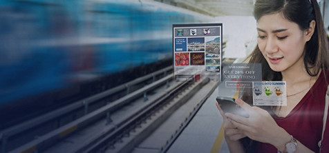 Jeune femme brune aux cheveux longs, sur un quai de gare regardant sont smartphone avec en toile de fond l'image floutée d'un train passant à grande vitesse