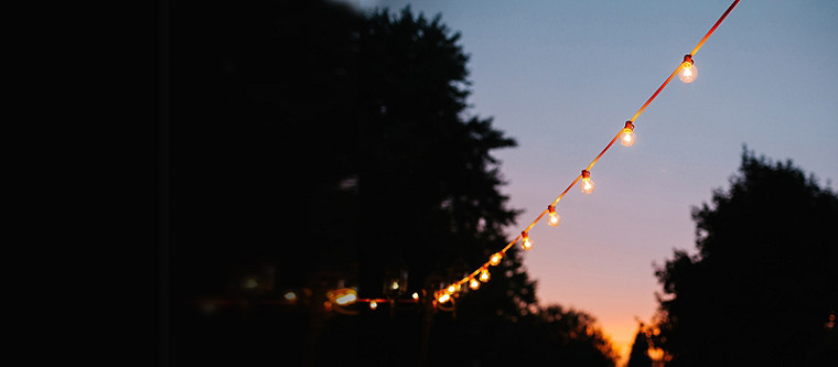 Eine Kette dekorativer Lichter in einem offenen Garten