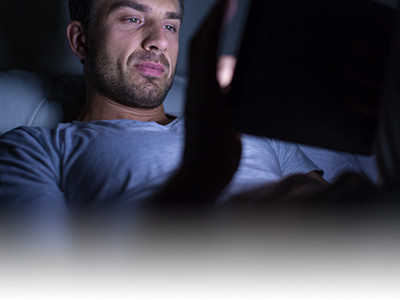 Hombre navegando en su tablet por la noche