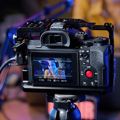Tittar på baksidan av en digitalkamera, som visar bilden av en talande kvinna