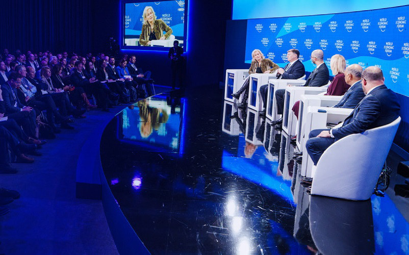 panelists sitting on a stage at the World Economic Forum event