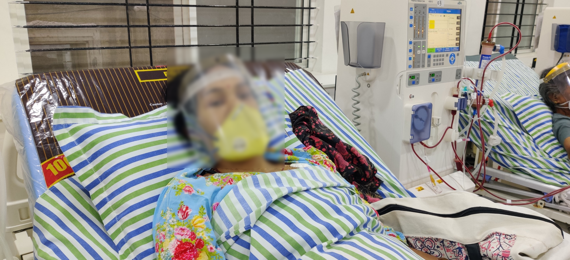 woman wearing a mask whose face is blurred sleeping on the hospital bed